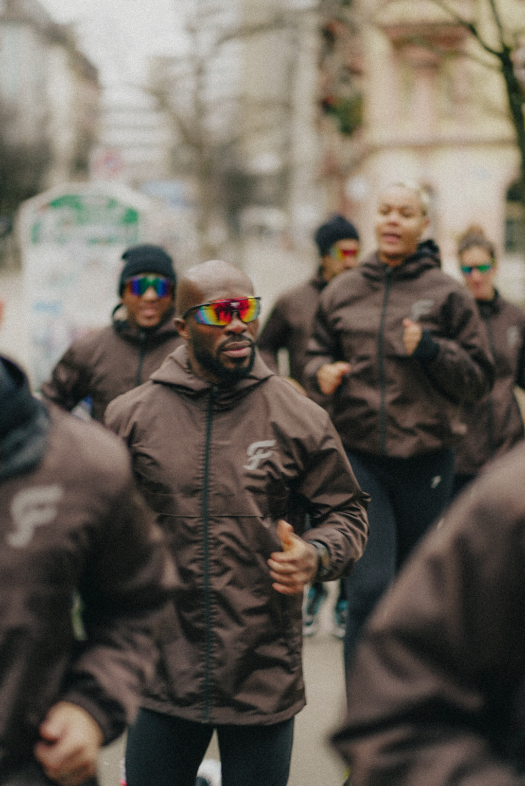 Runner leading the group in the FLEUVE rain jacket